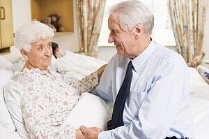 Senior Man Sitting With His Wife In Hospital