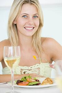 Young Woman Enjoying meal, mealtime With A Glass Of Wine