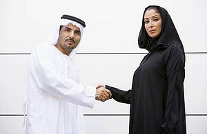 Two businesspeople standing outdoors shaking hands