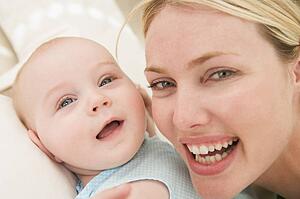 Mother and baby indoors smiling