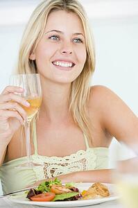 Young Woman Enjoying meal, mealtime With A Glass Of Wine