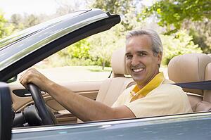 Man in convertible car smiling