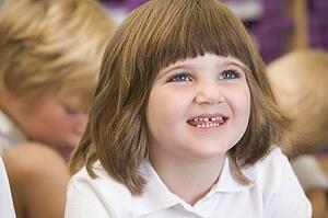Student in class sitting on floor with students in background (selective focus)