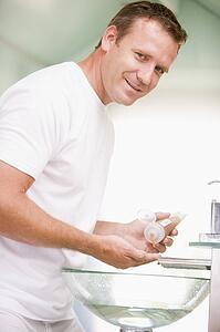 Man in bathroom with hair gel smiling