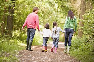 Family walking on path holding hands