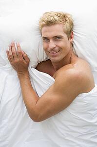 Man lying in bed smiling