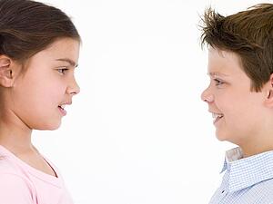 Brother and sister looking at each other smiling