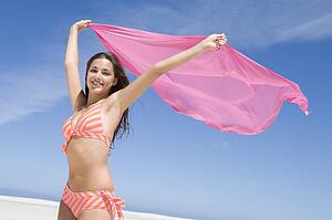 Young woman posing with a scarf on a beach