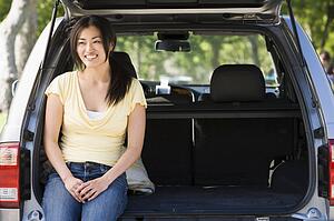Woman sitting in back of van smiling