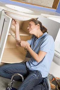 Plumber working on sink smiling