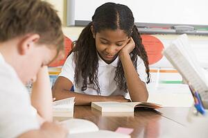 Students in class reading books (selective focus)