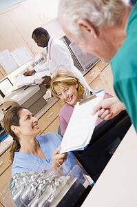 Nurses Being Handed A Clipboard At The Reception Area In A Hospital