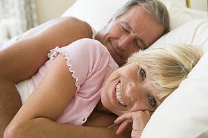 Couple lying in bed together smiling
