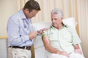 Doctor giving man needle in exam room