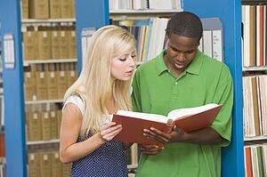 Man and woman in library reading book (depth of field)