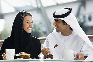 Couple at restaurant eating dessert and smiling (selective focus)