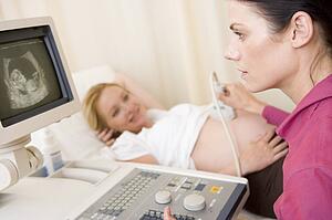 Pregnant woman getting ultrasound from doctor