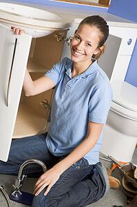 Plumber working on sink smiling