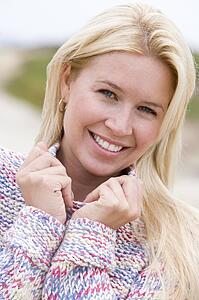 Woman standing at beach smiling