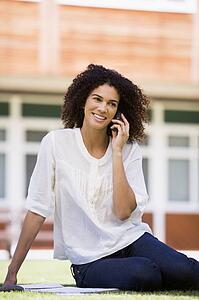 Woman on lawn of school using cellular phone