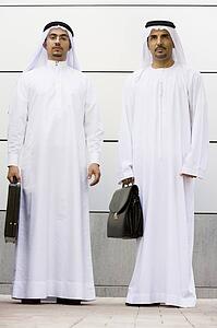 Two businessmen standing outdoors with briefcases