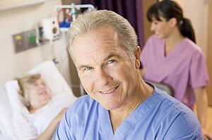 Doctor Standing In Patients Room, Nurse Checking Up On Patient