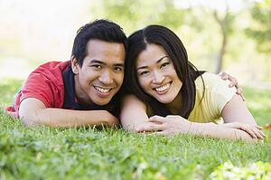 Couple lying outdoors smiling
