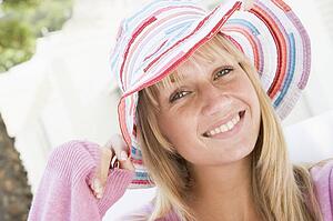 Blonde woman in a pink sweater posing outdoors