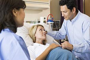 Doctor Talking To Pregnant Woman And Her Husband