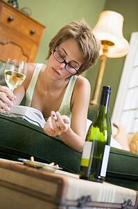 Young woman at home smoking and drinking wine by telephone