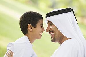 Man and young boy outdoors in park smiling (selective focus)