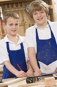 Male students reviewing woodworking plans