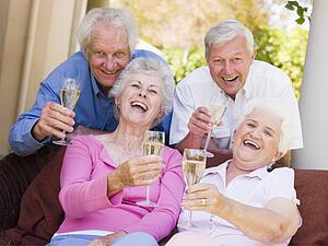 Two couples on patio drinking champagne and smiling