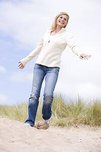 Woman walking on beach smiling