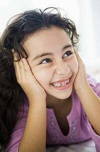 Young girl in living room smiling (high key/selective focus)