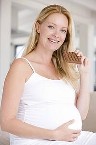 Pregnant woman with chocolate smiling