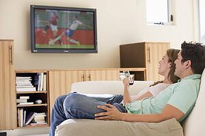 Couple in living room watching television