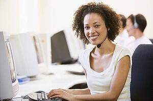 Woman wearing headset in computer room smiling
