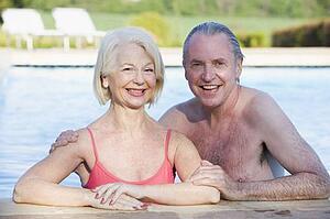 Couple in outdoor pool smiling