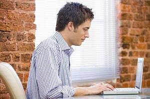 Businessman sitting in office with laptop