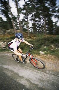 Man outdoors on trails riding bicycle (selective focus)
