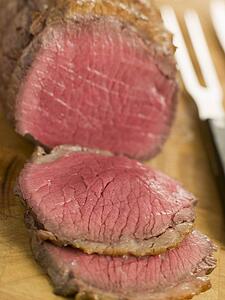 Roast Topside of British Beef carved on a Chopping Board