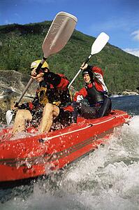 Two kayakers going into in rapids and smiling (selective focus)