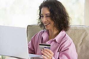 Woman with a laptop computer making an online purchase with credit card