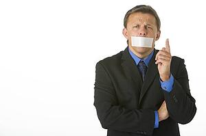 Businessman With His Mouth Taped Shut And Pointing 