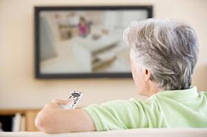 Man watching television using remote control