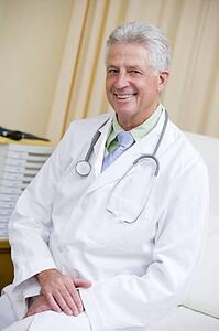 A Doctor Sitting On A Hospital Bed