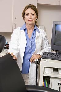 A Doctor Standing By A Computer Monitor