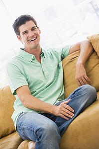Man sitting in living room laughing