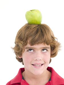 Young boy with apple on his head smiling